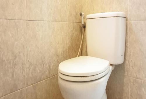 a bathroom with a white toilet in a room at Hotel Mataram Cipanas Syariah Mitra RedDoorz in Pasakon 1