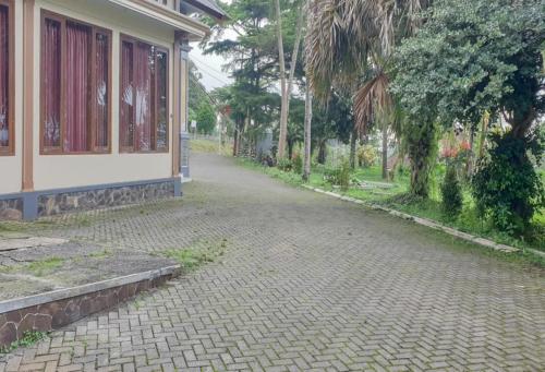 a cobblestone street next to a house at Hotel Mataram Cipanas Syariah Mitra RedDoorz in Pasakon 1