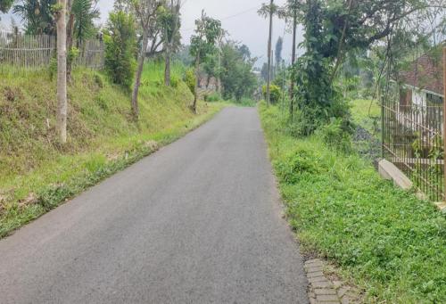 an empty road in the middle of a field at Hotel Mataram Cipanas Syariah Mitra RedDoorz in Pasakon 1