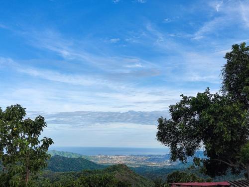 a view of the ocean from a hill with trees at El Refugio Minca in Minca