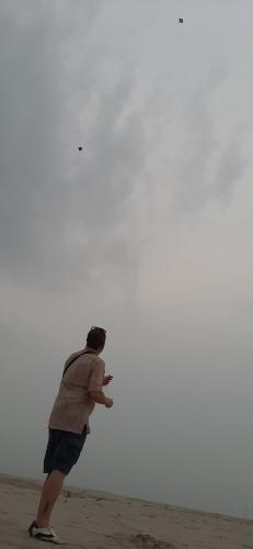 a man is flying a kite on the beach at MONALISA HOSTEL in Varanasi