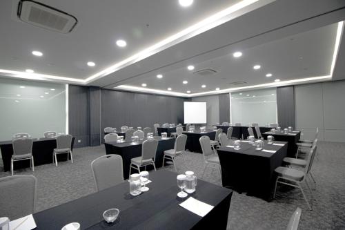 a conference room with tables and chairs and a screen at Laska Hotel Subang in Subang