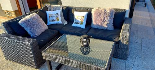 a blue couch with pillows and a glass table at Chata Stylchyn in Kluszkowce