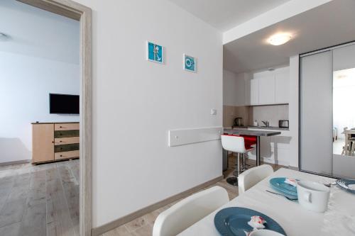 un salon avec une table, des chaises et un miroir dans l'établissement Apartament YAGI z bezpłatnym parkingiem Dziwnówek nad morzem EPapartamenty, à Dziwnówek