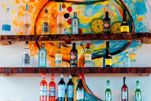 a wall filled with lots of bottles of alcohol at Ocean Breeze Hotel in Nungwi