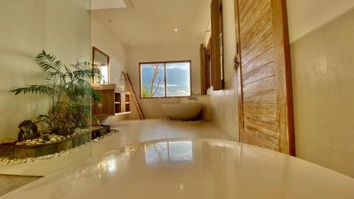 baño grande con bañera y baño en The Kama, en Nusa Penida