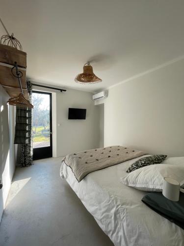 une chambre avec un grand lit et une fenêtre dans l'établissement La Maison Barbentane, à Barbentane