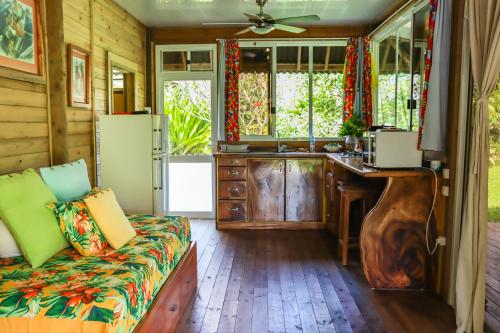 uma cozinha com um sofá e um lavatório num quarto em Bungalow Bali Hai em Fare