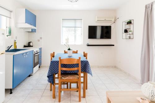 a kitchen and dining room with a blue table and chairs at Alexandros Luxury Apartments Nydri in Nydri