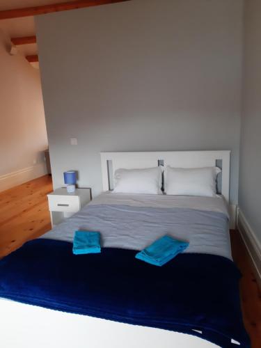 a bedroom with a bed with two blue towels on it at São Bartolomeu Apartment 4 in Coimbra