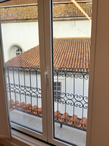 an open window with a view of a tile roof at São Bartolomeu Apartment 4 in Coimbra