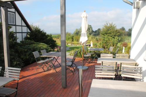 a patio with tables and chairs and an umbrella at H.W.S. Hotel Der Wilde Schwan in Sagard