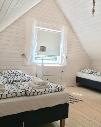 a attic bedroom with two beds and a window at 8 Sosen Pobierowo in Pobierowo