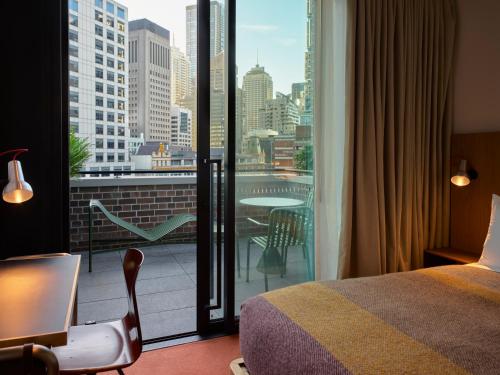 ein Hotelzimmer mit einem Bett und einem Balkon mit Aussicht in der Unterkunft Ace Hotel Sydney in Sydney