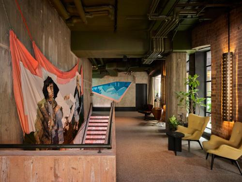 a hallway with a painting of a man on a wall at Ace Hotel Sydney in Sydney