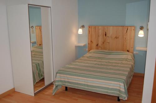 a small bedroom with a bed and a mirror at Amplio estudio en centro y playa Victoria 13 in Málaga