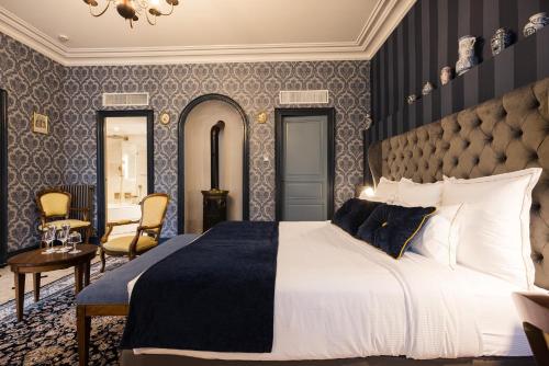 a bedroom with a large bed with blue and gray wallpaper at LE PETIT MANOIR in Sarlat-la-Canéda