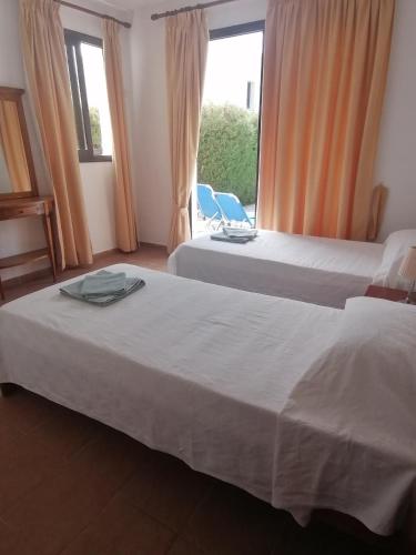 two beds in a hotel room with a window at Spacious 3 bedroom villa private pool in Paphos
