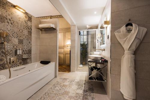 a bathroom with a tub and a walk in shower at LE PETIT MANOIR in Sarlat-la-Canéda