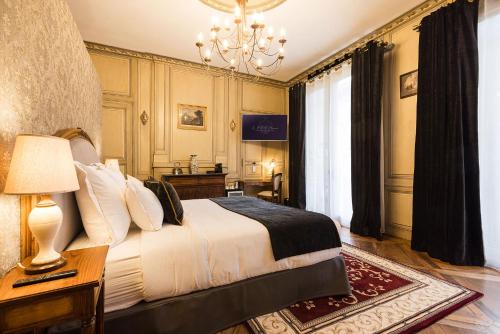 a bedroom with a bed and a chandelier at LE PETIT MANOIR in Sarlat-la-Canéda
