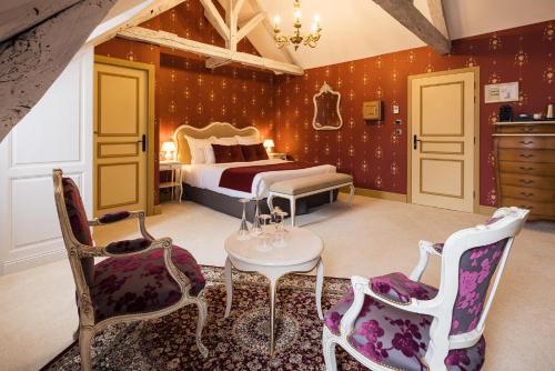 a bedroom with a bed and a table and chairs at LE PETIT MANOIR in Sarlat-la-Canéda