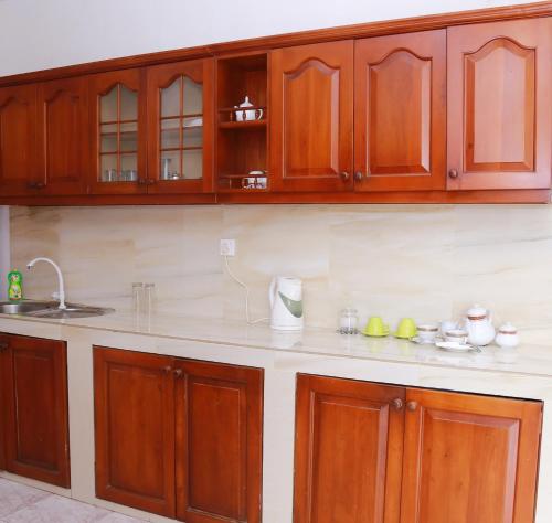 a kitchen with wooden cabinets and a counter top at Hillstreet Villa in Dehiwala