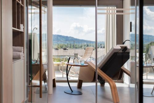 a room with a piano and a table and a balcony at hirschen dornbirn - das boutiquestyle hotel - skyrelax & wellness im rooftop in Dornbirn