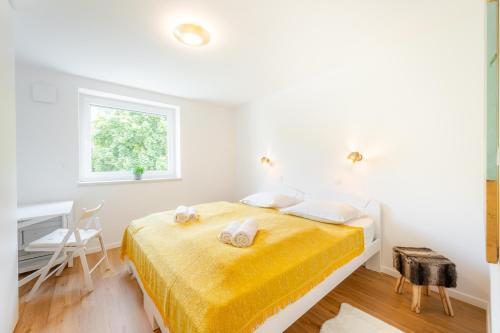 a white bedroom with a bed and a desk at APARTMENT 396 in Ljubljana
