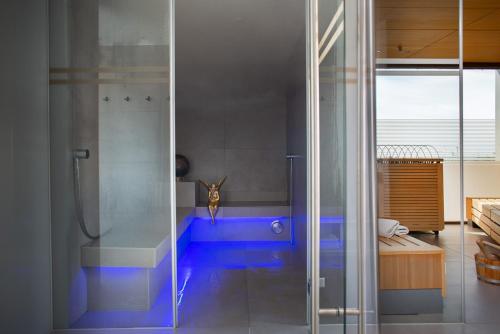 een badkamer met een douche en een blauw bad bij hirschen dornbirn - das boutiquestyle hotel in Dornbirn