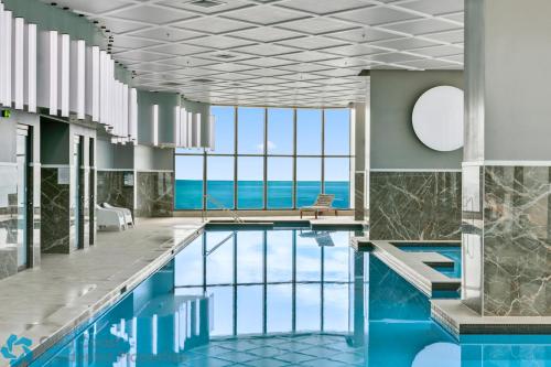 a pool in a hotel with a view of the ocean at Ocean Surfers Paradise - gclr in Gold Coast