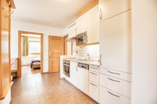 a kitchen with white cabinets and a sink at Landhaus Anja in Neustift im Stubaital