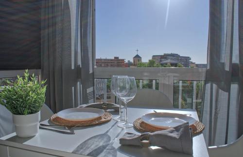 een tafel met borden en wijnglazen op een balkon bij Parque de la Paloma Area - Benalmadena Costa in Benalmádena