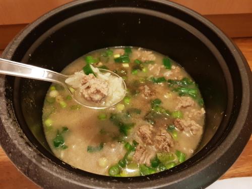 a bowl of soup with a spoon in it at Pranot Apartment & Spa in Nonthaburi