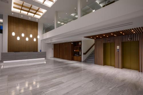 an empty lobby with a large room with wood floors at Pharae Palace in Kalamata