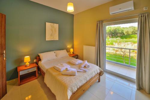 a bedroom with a bed with towels and a window at Naiades Summer House I in Plátanos