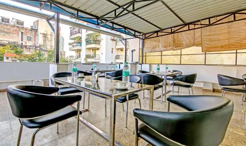 un restaurante con sillas negras y una mesa en Treebo Sai Village Gold Souk - Sec 43, en Gurgaon