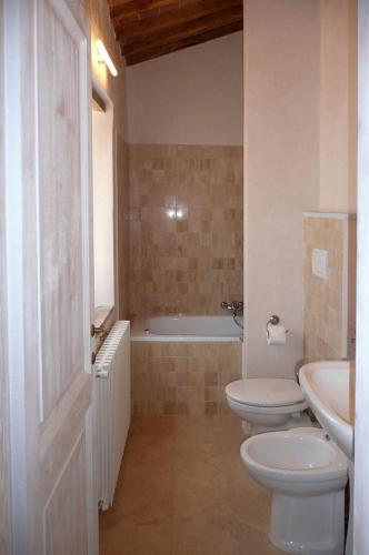 a bathroom with a tub and a toilet and a sink at Holiday home Cielsereno in Radicondoli