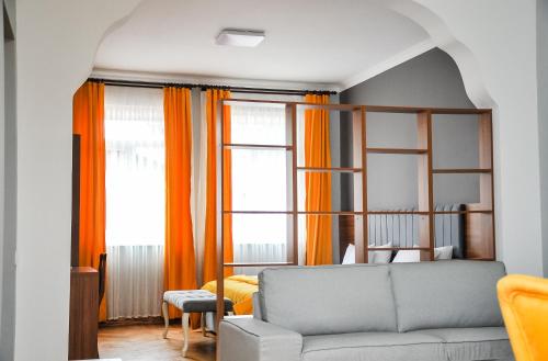 a living room with a couch and orange curtains at Palm Hotel in Batumi