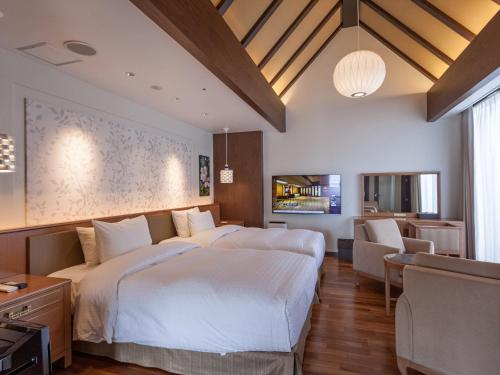 a bedroom with two beds and a living room at Okinawa EXES Naha in Naha