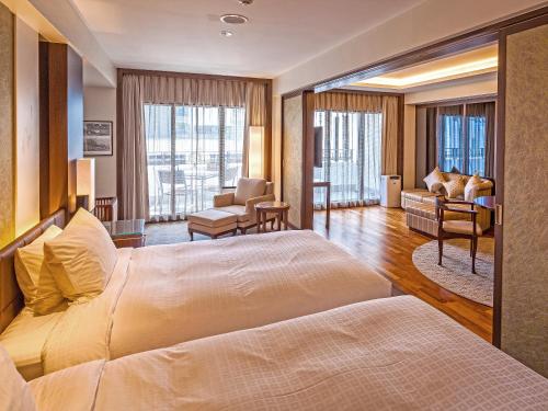 a hotel room with a bed and a living room at Okinawa EXES Naha in Naha