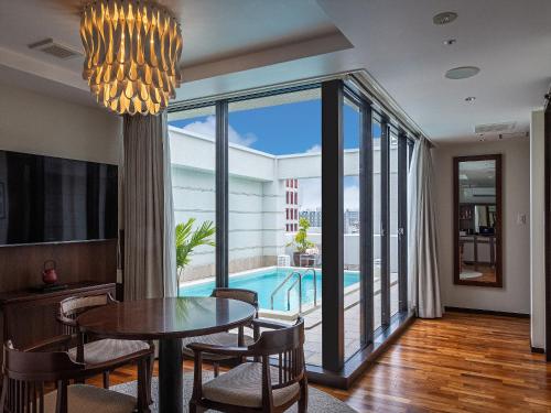 comedor con mesa y vistas a la piscina en Okinawa EXES Naha, en Naha