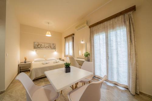 a room with a bed and a table and chairs at Frank Apartments in Amoudara Herakliou