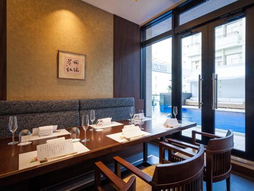 a dining room with a long table and chairs at Okinawa EXES Naha in Naha
