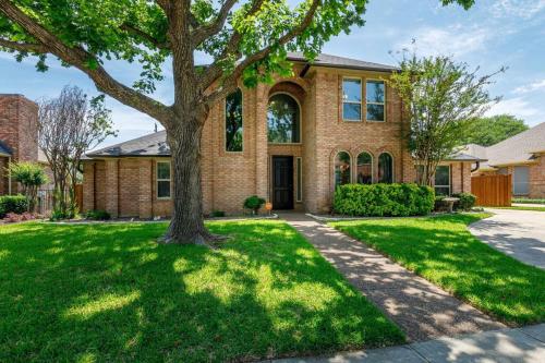 a brick house with a tree in the yard at Large Executive Family Home with Pool near DFW Airport in Keller