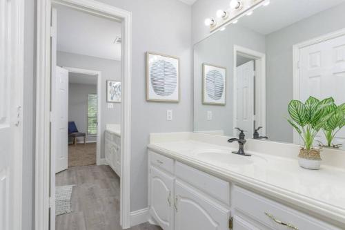 a white bathroom with a sink and a mirror at Large Executive Family Home with Pool near DFW Airport in Keller