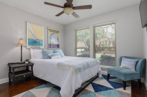 a bedroom with a bed and a blue chair at Large Executive Family Home with Pool near DFW Airport in Keller