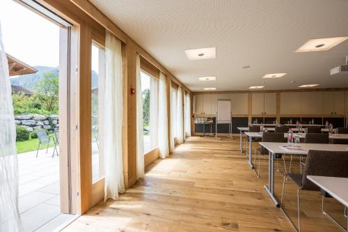 a classroom with tables and chairs and large windows at Hotel Spitzhorn Superieur in Gstaad