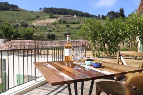 a bottle of wine sitting on a wooden table with a glass at Domaine de La Font des Pères - Teritoria in Le Beausset