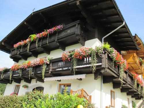 ein Gebäude mit einem Balkon mit Blumen darauf in der Unterkunft Haus Bergfried in Westendorf