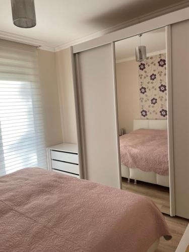 a bedroom with a bed and a large mirror at Luxus Apartment direkt am See in Csopak